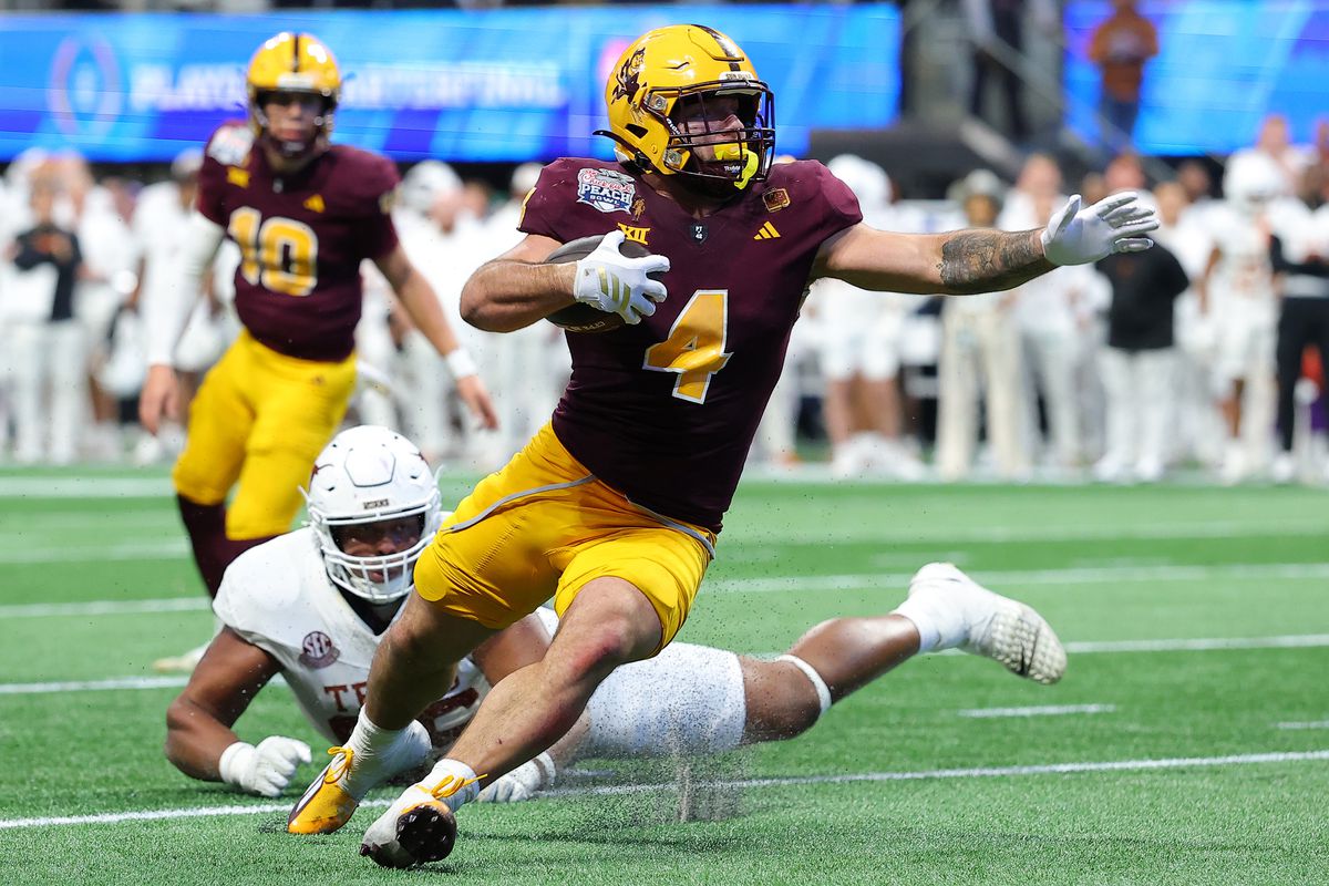 Cam Skattebo surges past defenders during a college football game