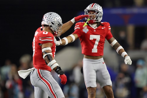 Jordan Hancock covers a receiver during a college football game, showcasing his defensive skills for Ohio State.