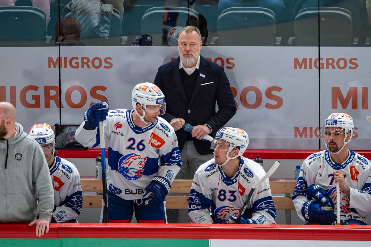 Mike Sullivan behind the bench with focused players during a Penguins game