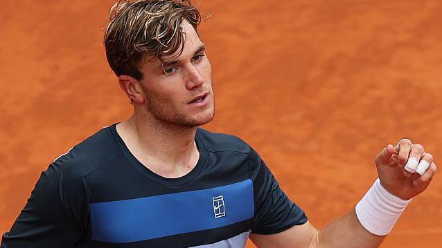 Lorenzo Musetti prepares to serve during the Madrid Open, focused and determined on the clay court.