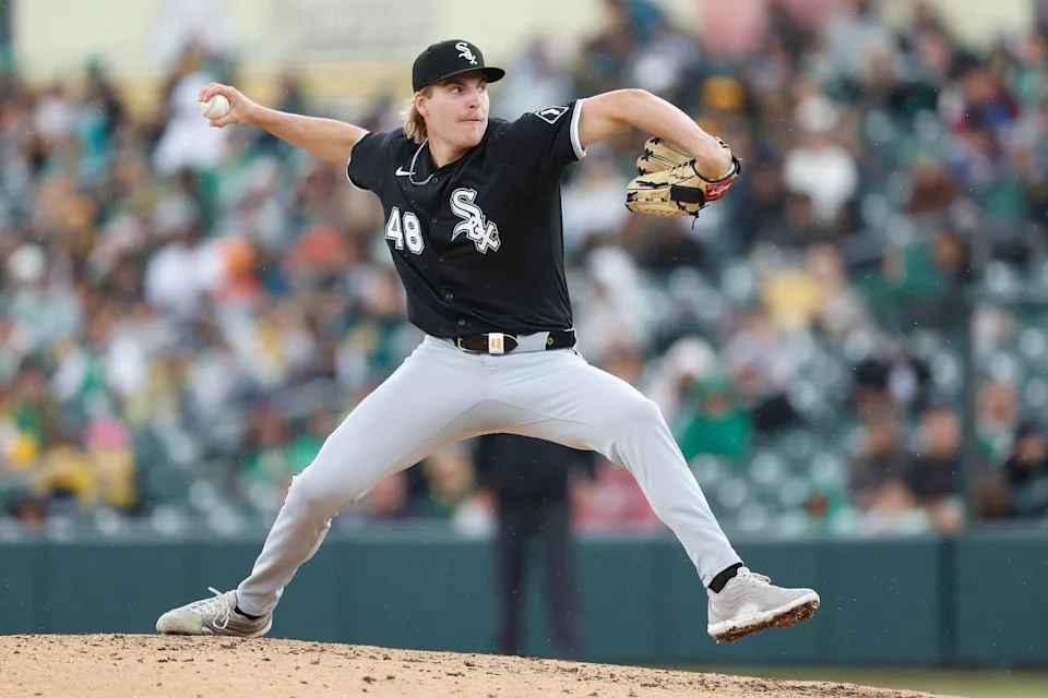 A White Sox batter awaits the pitch as fans watch from behind home plate