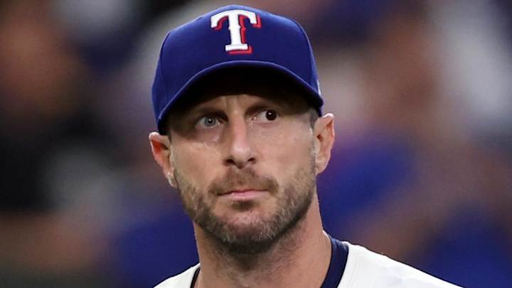 Max Scherzer in the Blue Jays dugout, flipping a coin to mimic umpire ball and strike calls