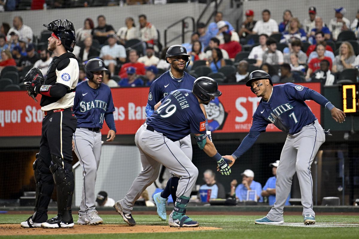 Cal Raleigh celebrates at home plate after his grand slam against the Rangers.