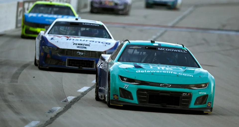 Michael McDowell races in the NASCAR Cup Series, showing determination and skill.