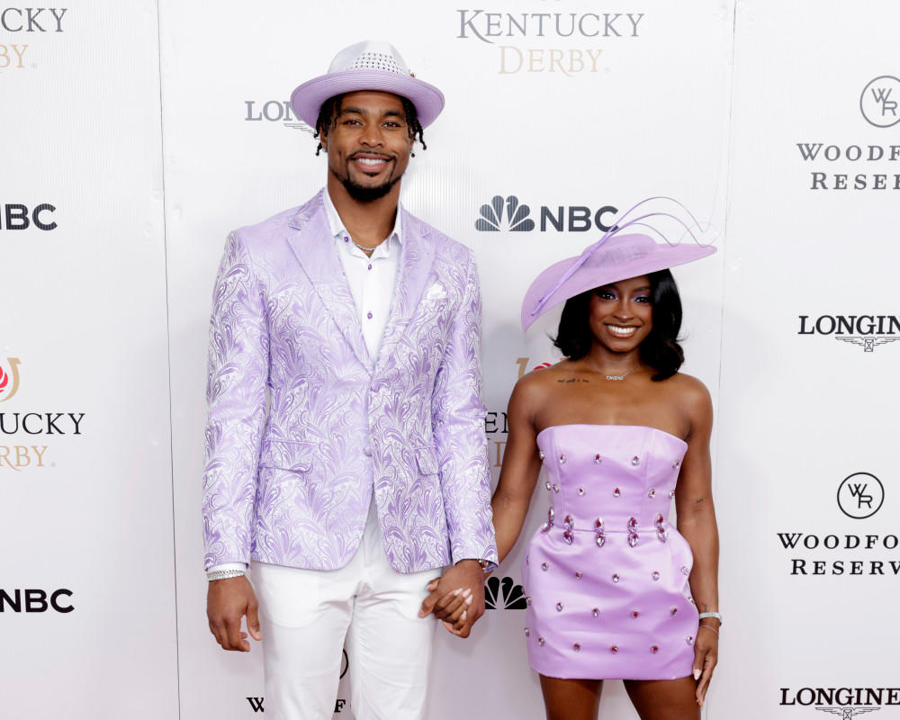 Simone Biles at Kentucky Derby 2025 in striking lavender attire, giving the "Riders Up" call