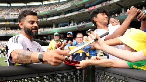 Indian cricket star Virat Kohli saluting fans at a stadium