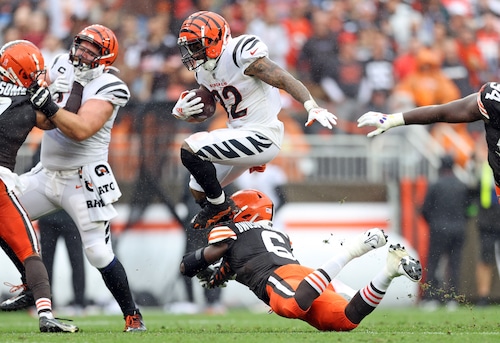 Trayveon Williams leaping over a defender, showcasing his athleticism as a running back