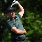 tiger woods smiling in golf attire at a major championship