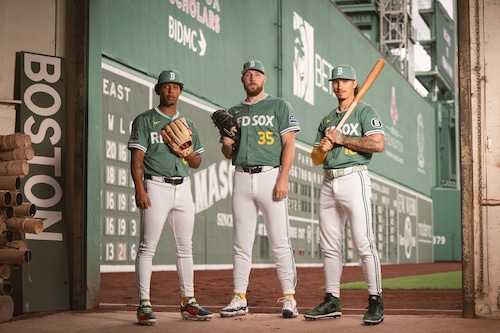 Red Sox City Connect jerseys in front of the Green Monster at Fenway Park