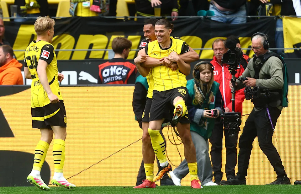 Dortmund players celebrate a key Bundesliga victory to secure Champions League qualification