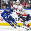 Players in action during the Panthers vs Maple Leafs Game 7, vying for the puck in a tense moment.